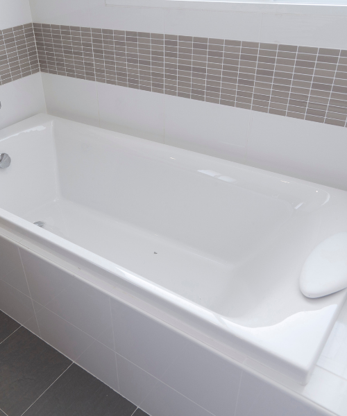 A white bath tub sitting on top of a tiled floor