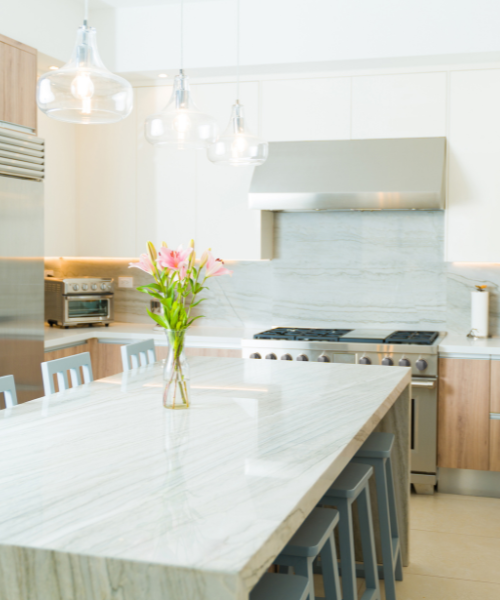 A kitchen with a marble counter top and stainless steel appliances