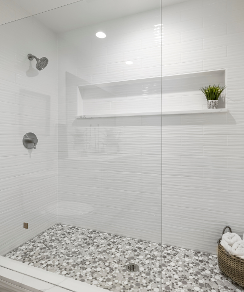 A white bathroom with a glass shower door