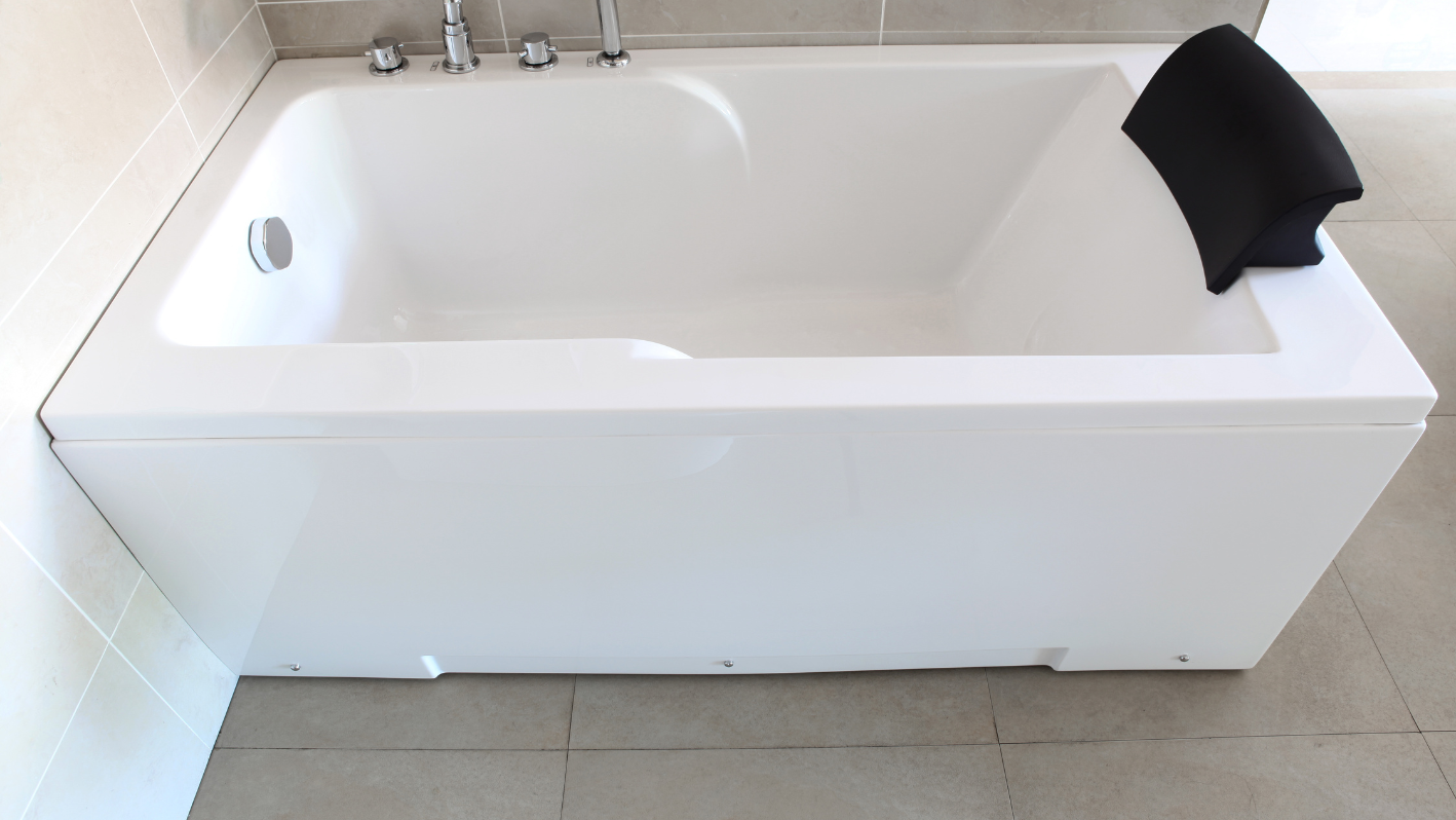 A white bath tub sitting on top of a tiled floor