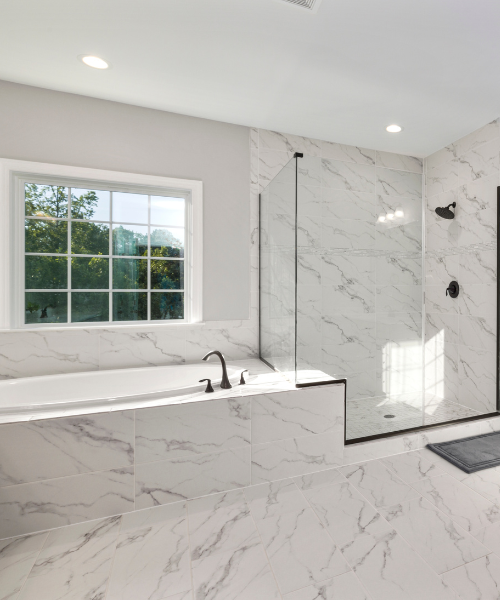 A white marble bathroom with a walk in shower