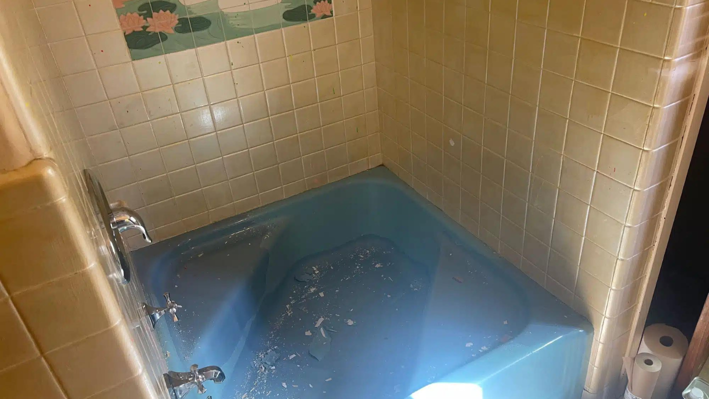 A blue bath tub sitting inside of a bathroom