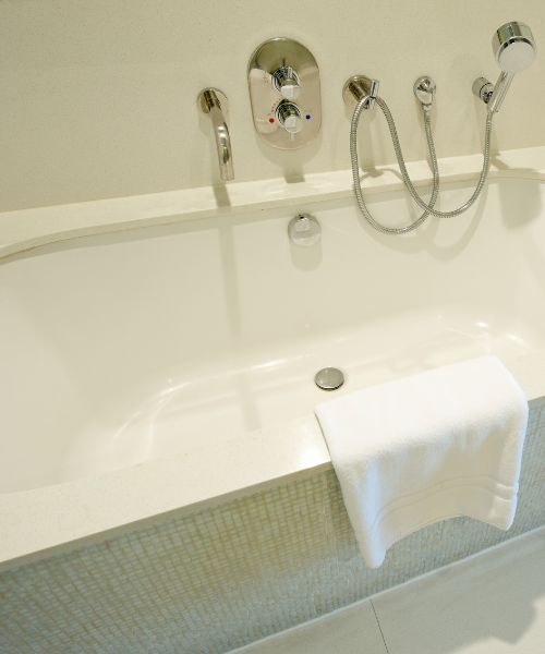 A white bath tub sitting next to a shower head