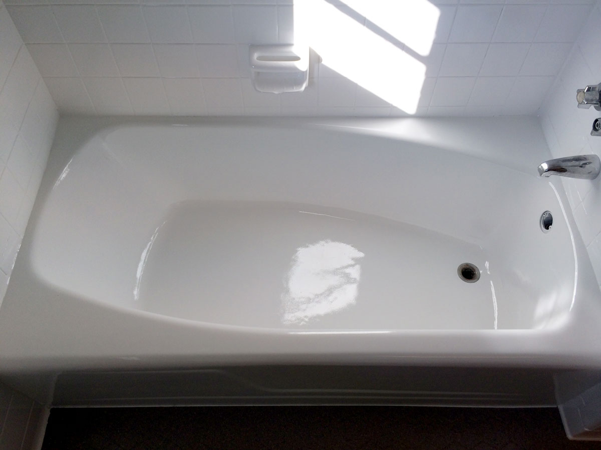 A white bath tub sitting under a window