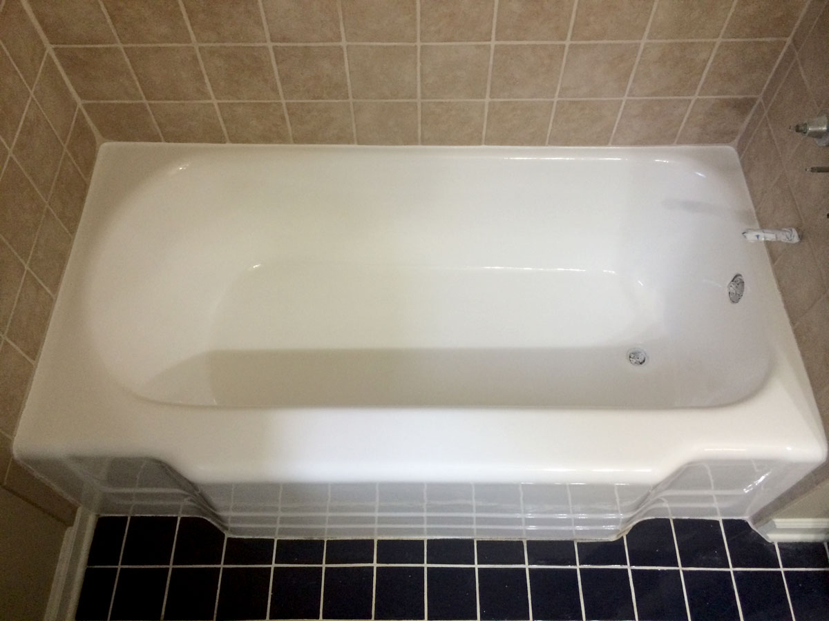 A white bath tub sitting in a bathroom next to a tiled floor