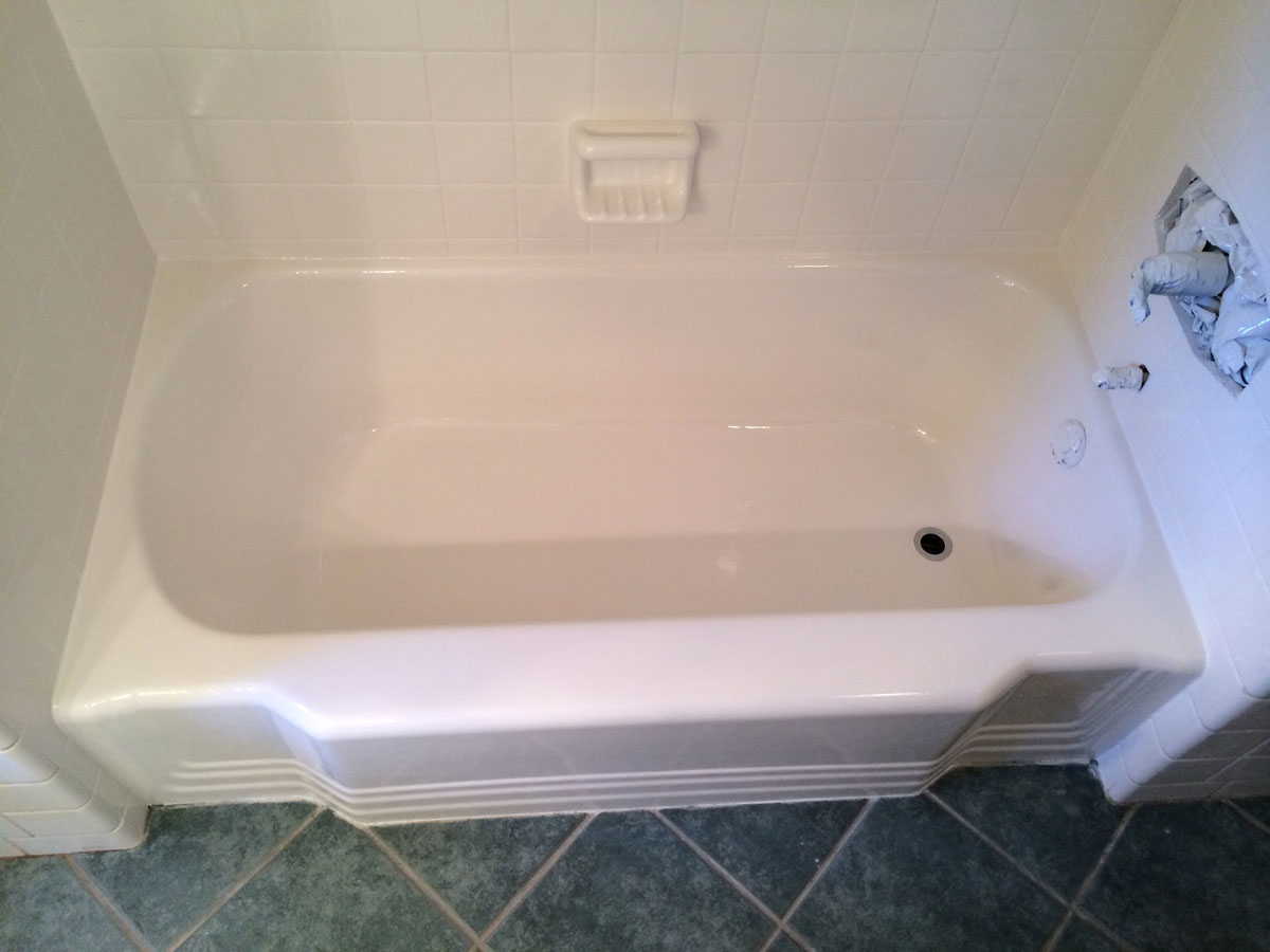 A white bath tub sitting on top of a tiled floor