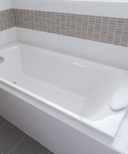 White bathtub on a tiled bathroom floor