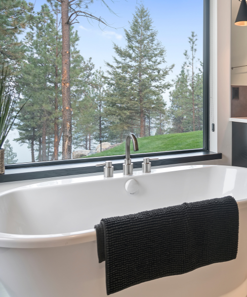 White bathtub beside a bathroom window